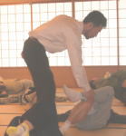腰痛アカデミーで腰痛やヘルニア、狭窄症、坐骨神経痛を治す坂戸孝志先生による個別サポートの様子